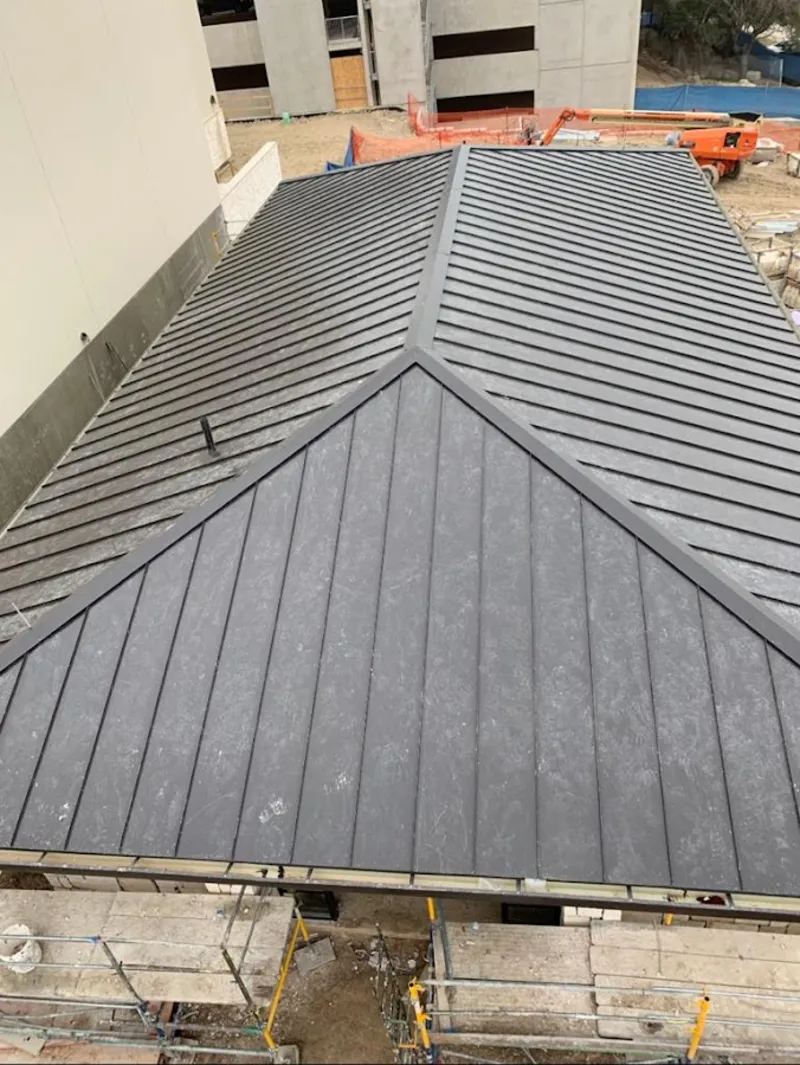 Commercial metal roof construction with crane equipment in West Pensacola