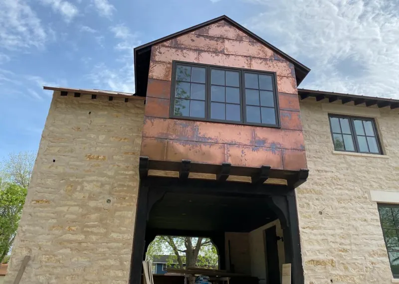 Copper metal panel facade on a stone building for Skylight Installation in West Pensacola
